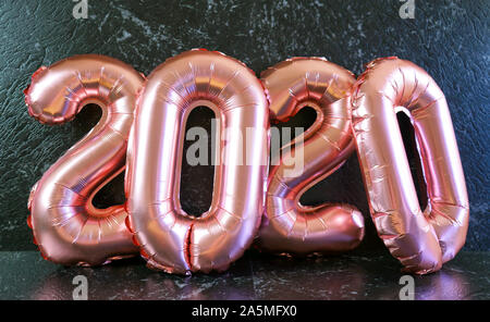 Silvester 2020 Anzahl Rose Gold Pink Metallic Ballons auf schwarzem Marmor Hintergrund Tabelle. Stockfoto