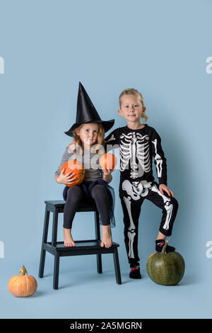 Doppelzimmer Portrait von Bruder und Schwester in Halloween Kostüme mit Kürbissen. Stockfoto