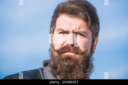 In stilvollen Auftritt investieren. Dicken Bart wachsen schnell. Man bärtige Hipster tragen Anzug und blauer Himmel. Gesichtsbehaarung Bart und Schnurrbart. Bart Fashion Trend. Jeder Bart ist völlig einzigartig. Stockfoto