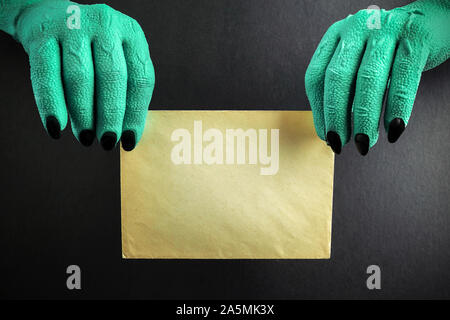 Halloween grüne Hexen oder Zombie monster Hände halten Leere auf schwarzem Hintergrund Stockfoto