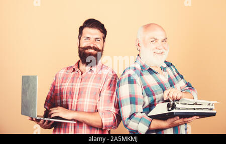 Alte generation. bärtigen Männern. Vintage Schreibmaschine. Vater und Sohn. Familie generation. retro Schreibmaschine laptop vs. Neue Technologie. Technologie Schlacht. Modernes Leben. Jugend vs Alter. business Ansatz. Stockfoto