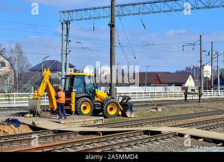 Gelben bulldozer trägt Aushubarbeiten durch, während der Konstruktion und Rekonstruktion von Schienen und Titel auf der Bahn Stockfoto