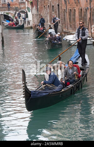 Eine Gruppe von Asiaten, voraussichtliche Chinesische, machen Sie eine Gondelfahrt auf dem Canal Grande in Venedig, Italien. Von der Rialtobrücke Stockfoto