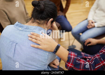 Rückansicht des jungen Mann weinend in Support Group mit dem Psychologen tröstet ihn, kopieren Raum Stockfoto