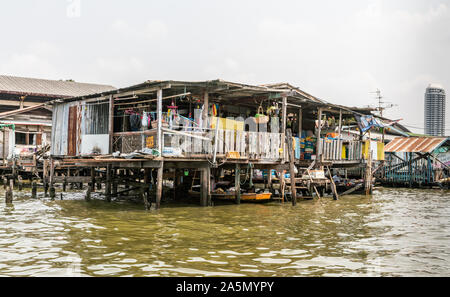 Die Stadt Bangkok, Thailand - 17. März 2019: Bangkok Noi Kanal. Verfallene schlechte Wohnverhältnisse auf Stelzen in das grünliche Wasser gebaut bietet chaotischen Ansicht unter s Stockfoto