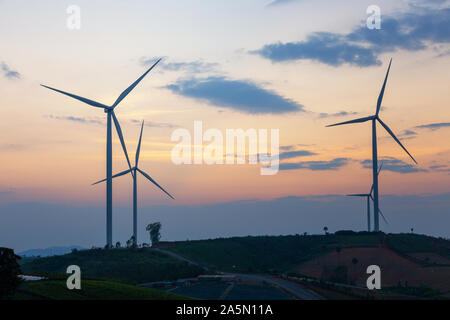 Windmühlen strom Pflanzenproduktion green energy Silhouette Sonnenuntergang auf dem Berg Stockfoto