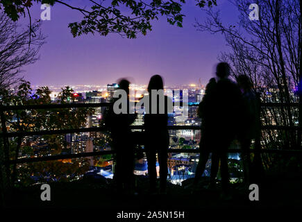 Personen und Blick auf die Innenstadt von Montreal in der Dämmerung von einem Aussichtspunkt auf dem Mont Royal, Kanada Stockfoto