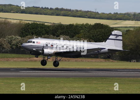 N 877 MG, eine Douglas DC-3 Dakota in der Pan American Airways Farben, die durch Prestwick Airport in Ayrshire, vorbei an den Daks über der Normandie Veranstaltung zu besuchen. Stockfoto