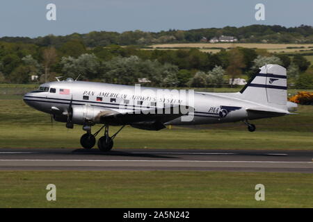 N 877 MG, eine Douglas DC-3 Dakota in der Pan American Airways Farben, die durch Prestwick Airport in Ayrshire, vorbei an den Daks über der Normandie Veranstaltung zu besuchen. Stockfoto