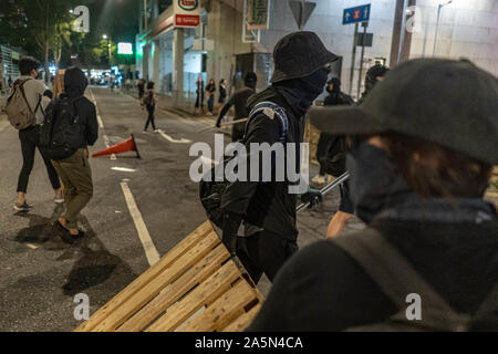Hongkong, China. Okt, 2019 21. Die demonstranten Errichten einer Barrikade auf der Straße während der Demonstration. Drei Monate nach dem "Yuen Long Railway Riot', Demonstranten um in Yuen Long versammelten ihre Wut auf die Polizei zum Ausdruck zu bringen. Die Demonstranten in Rechnung, dass die Polizei die Verantwortung für die Bewohner Sicherheit tragen sollten. Es dauerte 4 Stunden insgesamt für die Bereitschaftspolizei alle Demonstranten auf der Straße zu verteilen. Credit: SOPA Images Limited/Alamy leben Nachrichten Stockfoto