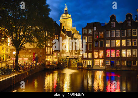 Nacht in Amsterdam, mit beleuchteten Gebäuden und ein Restaurant im Freien, Niederlande Stockfoto