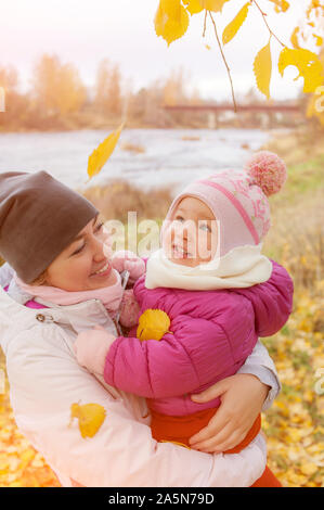 Portrait von Mutter und niedlichen Tochter umarmen im Freien. Gesunde Lebensweise. Familie outdoor. Herbst Herbst Jahreszeit. Herbst Natur. Glückliche Kindheit. Gesund Stockfoto