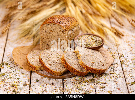 Brot mit verschiedenen Samen, Kürbis, Mohn, Flachs, Sonnenblumen-, Sesam, auf hölzernen Hintergrund Stockfoto