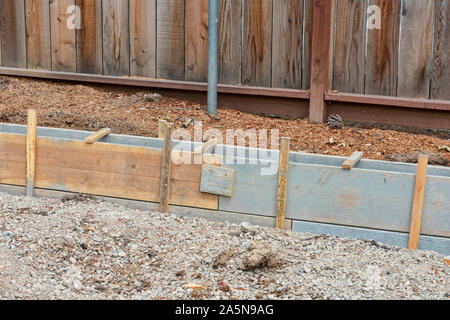 Betonaufkantung Bau. Ausgegraben. Holz Board befestigt aufrecht mit Holz Pfähle in den Boden getrieben. Gehsteig Bürgersteig Erneuerung. Stockfoto