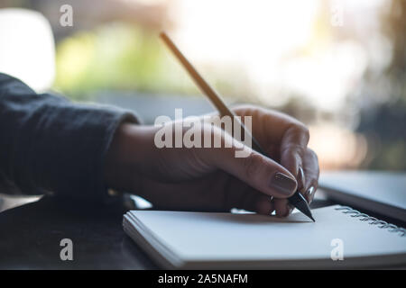 Closeup Bild der Hände einer Frau schreiben auf Notebook auf dem Tisch Stockfoto