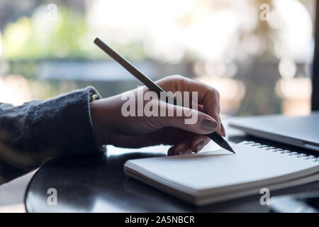 Closeup Bild der Hände einer Frau schreiben auf Notebook auf dem Tisch Stockfoto