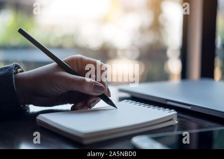 Closeup Bild der Hände einer Frau schreiben auf Notebook auf dem Tisch Stockfoto