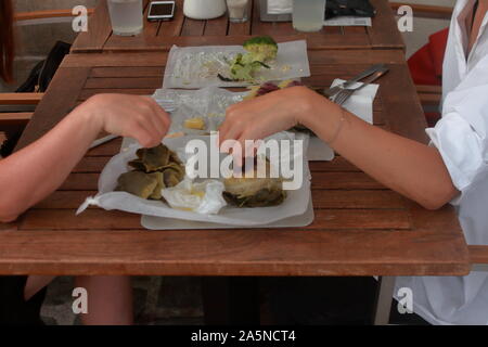 Zwei Mädchen essen eine jüdische Artischocke (Rezept) im jüdischen Viertel von Wien Stockfoto