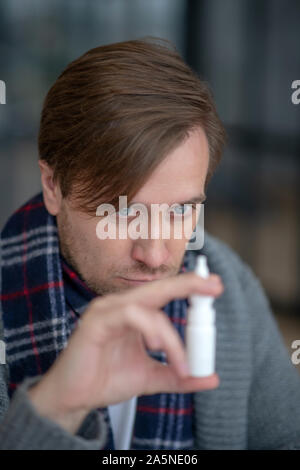 Der Mensch auf der Suche nach nasenspray beim haben verstopfte Nase Stockfoto