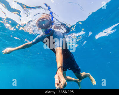 Mann mit Maske Schnorcheln im klaren Wasser Stockfoto