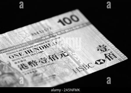 100 Hong Kong Dollar Banknote auf einem dunklen Hintergrund. Schwarz und Weiß Stockfoto