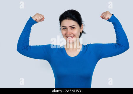 Stark, zielstrebig, selbstbewusste Frau mit der Faust heben, die Muskeln. Menschen vertrauen Ausdruck, Kraft und Motivation Konzept. Stockfoto