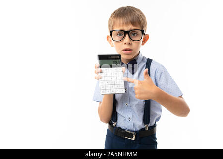 Little Boy in schwarz Brille mit transparenten Gläser, blaues Hemd, Pull-ups, blauen Hosen zeigt auf Rechner Stockfoto