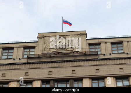 12-10-2019, Moskau, Russland. Das Wappen der UDSSR und der Flagge der Russischen Föderation auf dem Dach der Staatsduma. Sichel und Leinwand surro Stockfoto