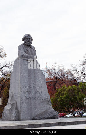 12-10-2019, Moskau, Russland. Denkmal für Karl Marx, der Begründer des Kommunismus. Der rote Stern der Moskauer Kreml ist neben der Skulptur sichtbar. Stockfoto