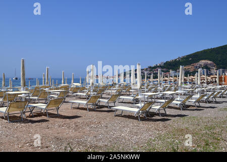 Budva, Montenegro - Juni 13.2019. Stadtstrand im Resortbereich mit geschlossenen Sonnenschirmen Stockfoto