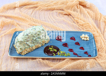 Mousse Gebäck Kuchen Dessert in grün Schokolade Glasur dekoriert und Pistazien. Stockfoto