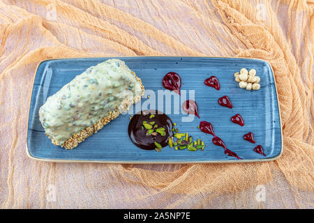 Mousse Gebäck Kuchen Dessert in grün Schokolade Glasur dekoriert und Pistazien. Stockfoto