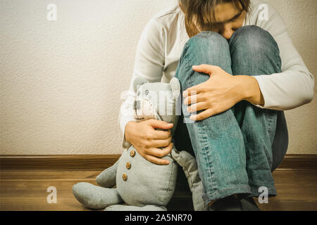 Pränatale Verlust Begriff - deprimiert Frau mit Teddybären Spielzeug Stockfoto