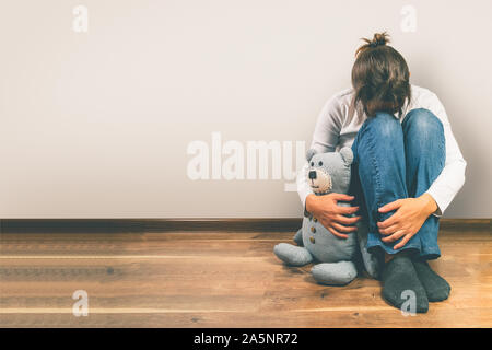 Pränatale Verlust Begriff - deprimiert Frau mit Teddybären Spielzeug Stockfoto