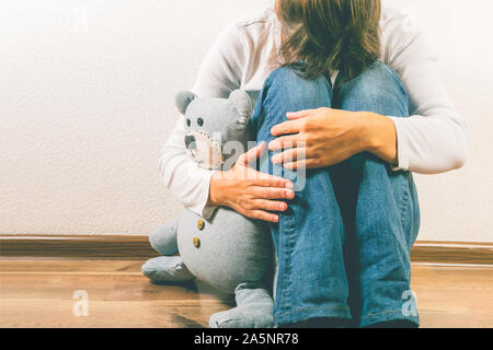 Pränatale Verlust Begriff - deprimiert Frau mit Teddybären Spielzeug Stockfoto