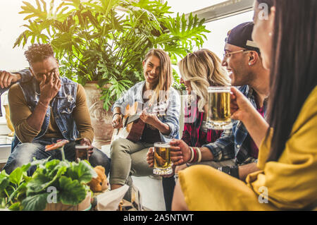 Gruppe von fröhlichen Menschen Bier trinken und Gitarre zu spielen. Junge Freunde lächelnd und gemeinsam Spaß haben Stockfoto