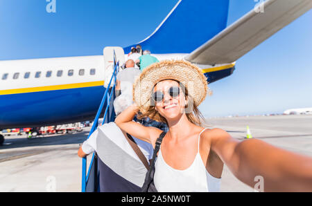 Junge Frau nimmt eine selfie am Flughafen vor einem Flugzeug vor dem Abflug. Konzept über Reisen und Technologie Stockfoto