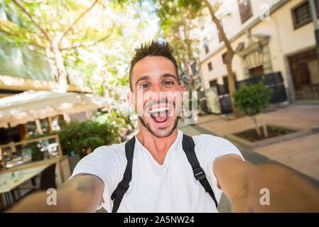 Schöner Mann nimmt einen selfie zu Fuß in der Stadt Stockfoto