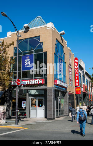 Victoria, British Columbia, Kanada. Menschen zu Fuß vorbei an einem McDonald's Fast Food Restaurant in der Innenstadt. Stockfoto