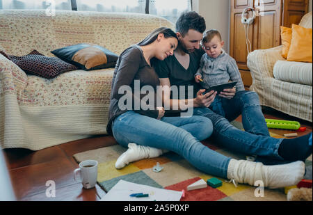 Familie mit Kind und schwangere Mutter tablet Stockfoto