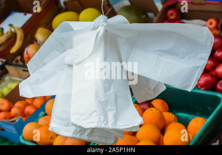 Single use Plastiktüten hängenden außerhalb der Laden neben dem Obst und Gemüse Stockfoto