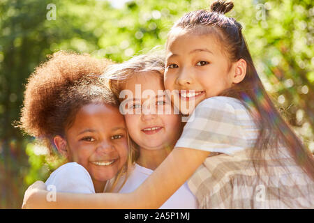 Drei multikulturelle Mädchen als Freundinnen in der Natur Stockfoto