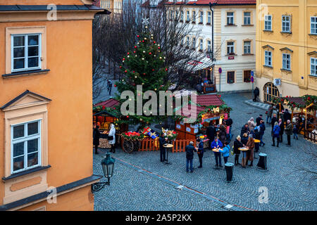 Menschen essen Essen auf kleinen gepflasterten Platz für Winterurlaub während der traditionelle Weihnachtsmarkt in Prag. Stockfoto