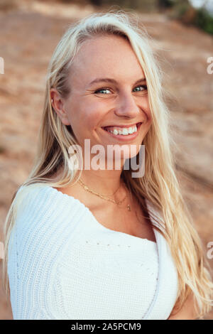 Porträt der schönen blonden Frau in weißem Kleid Stockfoto