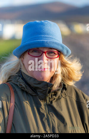 Ältere Frau mit Brille trägt einen blauen Wolle hat, Waterville, County Kerry, Irland Stockfoto