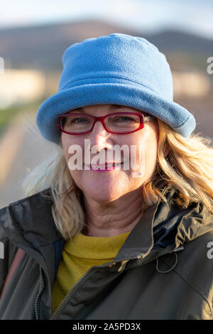 Ältere Frau mit Brille trägt einen blauen Wolle hat, Waterville, County Kerry, Irland Stockfoto