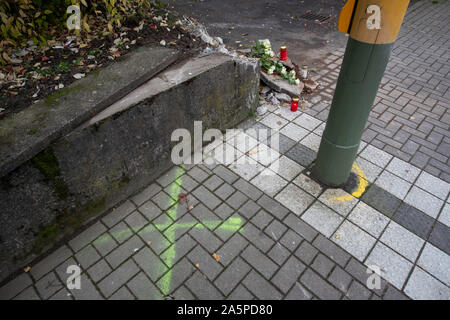 Bielefeld, Deutschland. 22 Okt, 2019. Ein gesprüht Kreuz, Kerzen und Blumen können bei einem Unfall in der Nähe von der Straße aus sehen. Nach einer Hochzeitsfeier, ein Familienauto mit sieben Passagiere in eine Wand auf einer nassen Fahrbahn in der Nacht des 21. Oktober abgestürzt. Zwei 16-Jährige sterben. Die Kinder in einem 7-Sitzer saßen, sagte ein Polizeisprecher. Zwei andere Kinder und Jugendliche im Alter zwischen 13 und 16 und drei Erwachsene verletzt worden, einige von ihnen schwer. Unter den Verletzten waren die Eltern eines der Opfer. Credit: Friso Gentsch/dpa/Alamy leben Nachrichten Stockfoto