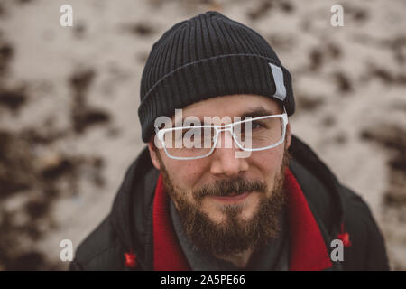 Porträt junger bärtiger Mann mit Brille Stockfoto