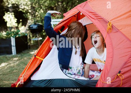 Bruder und Schwester im Zelt im Hinterhof Stockfoto