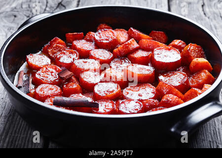 In der Nähe von kandierten Yamswurzeln, Thanksgiving süsse Kartoffeln gekocht mit Zimt, brauner Zucker und Butter in einem schwarzen Keramik Teller, horizontale Ansicht von oben Stockfoto